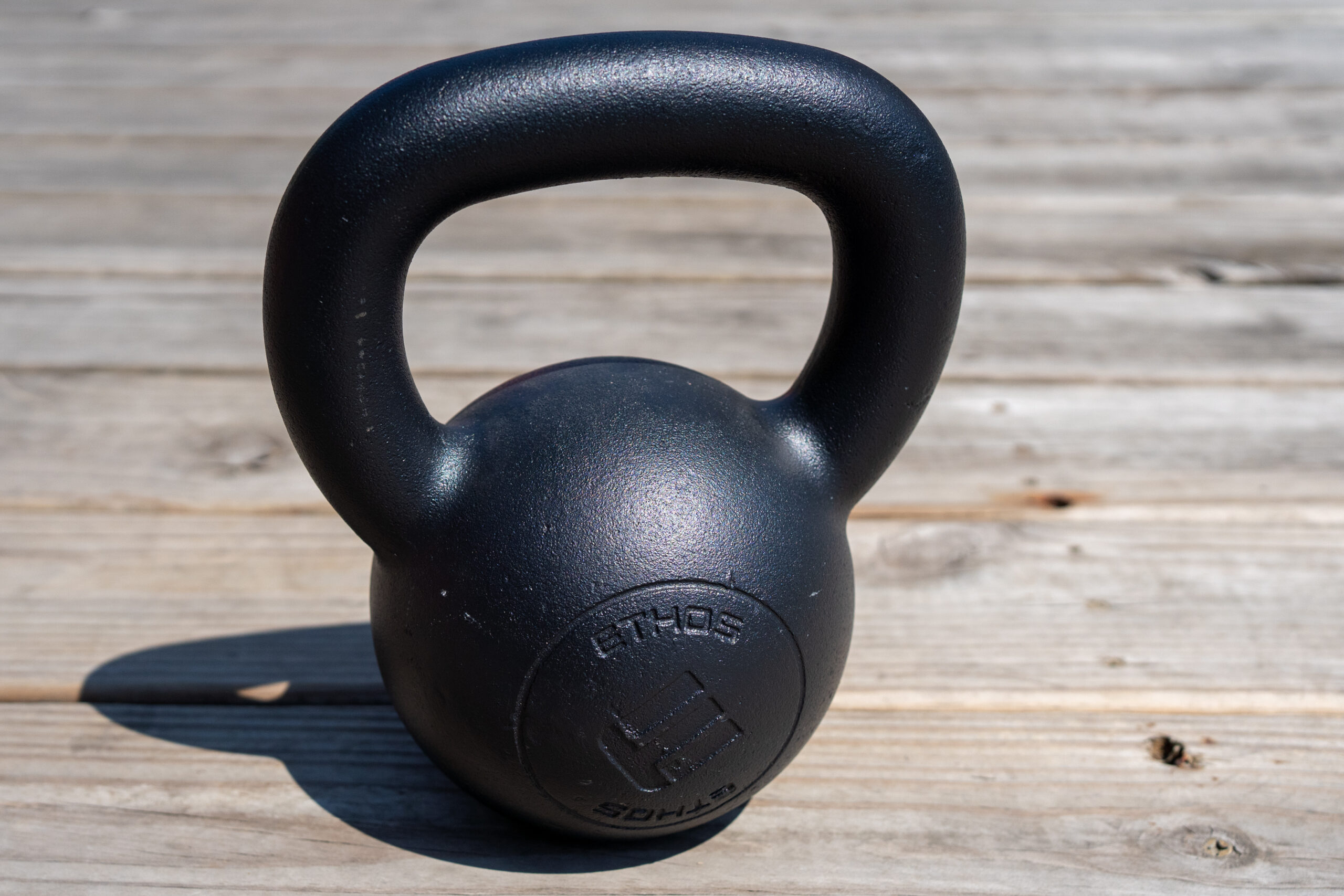 a kettlebell sits on wood planks