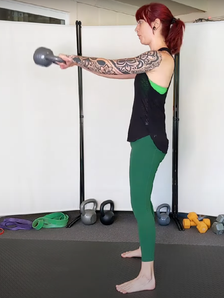 Woman demonstrating a kettlebell swing, to help answer the question "Should I lift weights?"