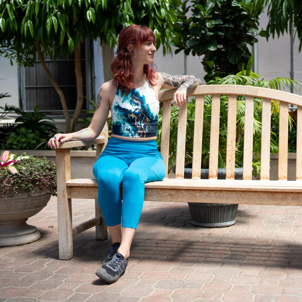 Sarah sits on a bench looking off to the side