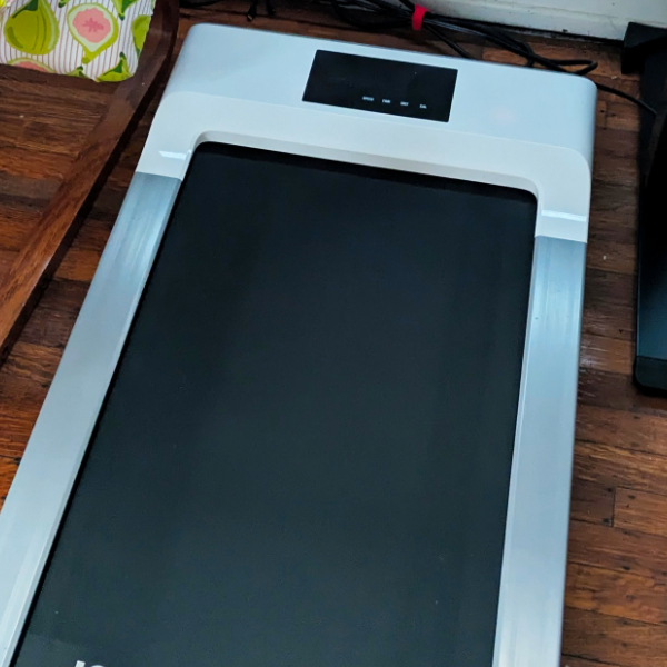 a white and grey walking pad on a wood floor
